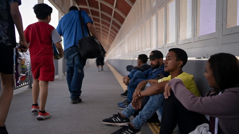 Migrants from Brazil sit on the Ysleta-Zaragoza Bridge connecting Juárez...