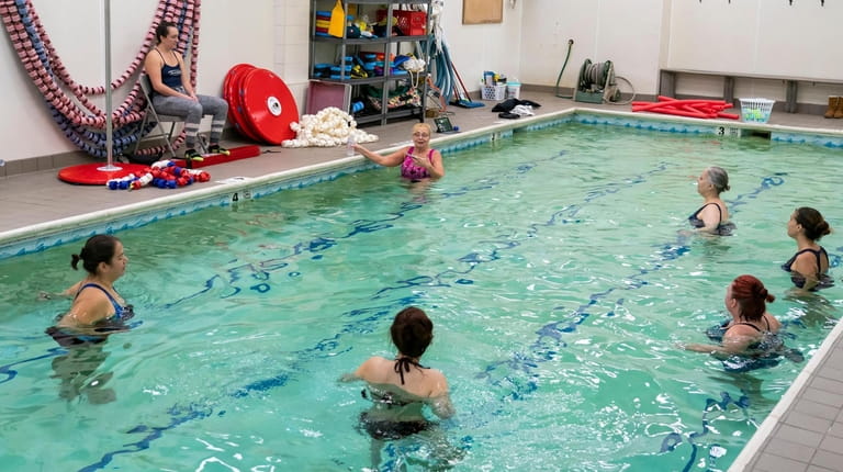 Lorraine Marx-Epstein, in background center, instructs a swim class in...