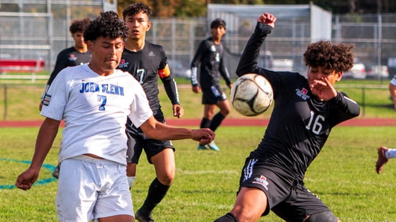 Glenn's Chris Flores and Amityville's Hector Mejia play the ball during a Suffolk...