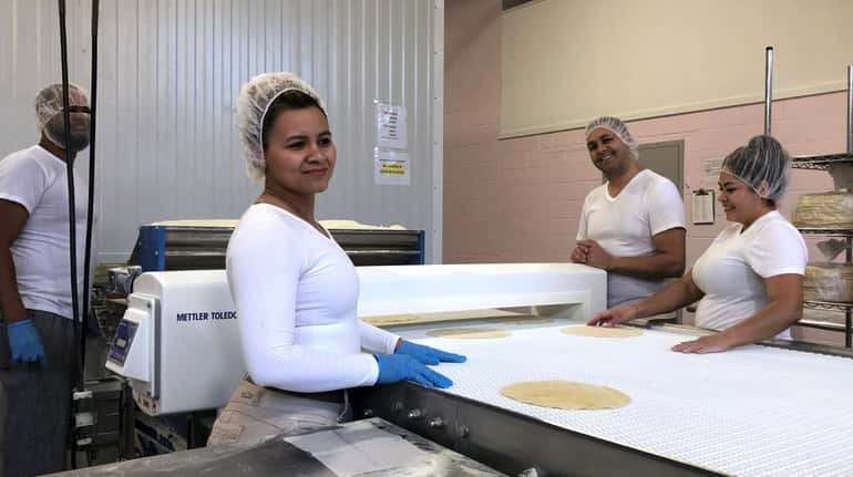 Employees at Ultra-Thin Pizza Shells & Flatbreads Co. make pizza...