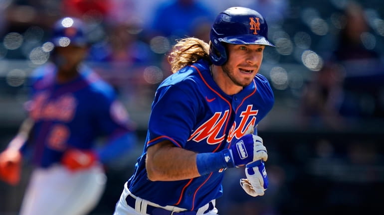 Mets' Travis Jankowski runs to first base as Dominic Smith...