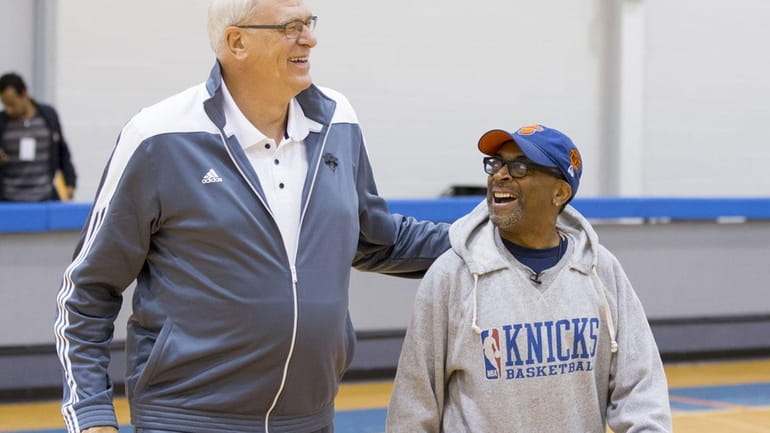 Knicks president Phil Jackson, left, walks with director Spike Lee.