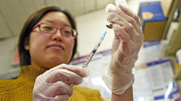 A pharmacist at West Hempstead Pharmacy prepares a flu vaccination...