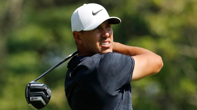Brooks Koepka watches his shot from the fourth tee during...