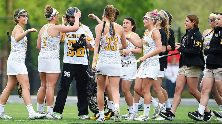 Adelphi goalkeeper Taylor Hayes is congratulated by her teammates after...