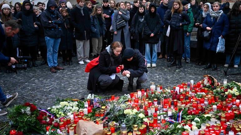 Mourners lay candle lights outside the headquarters of Charles University...