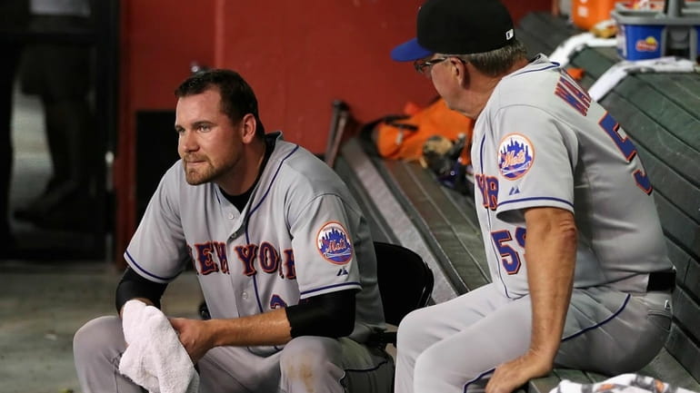 Starting pitcher Mike Pelfrey reacts in the dugout after being...