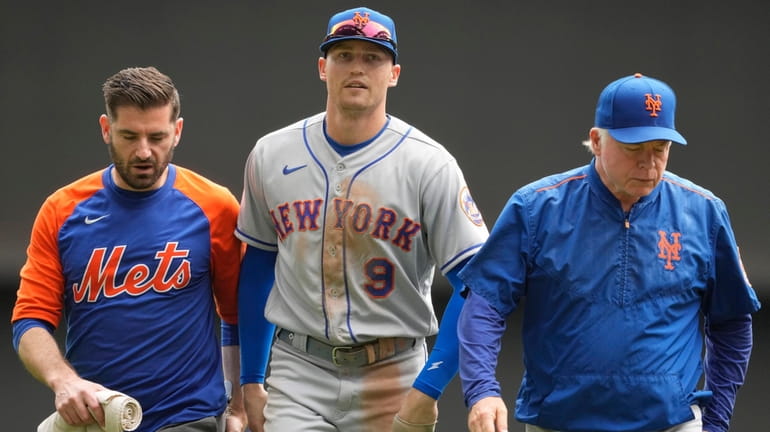 Brandon Nimmo of the Mets walks off the field with...