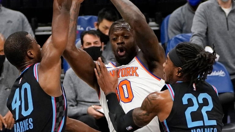 Knicks forward Julius Randle, center, is double-teamed by the Kings'...