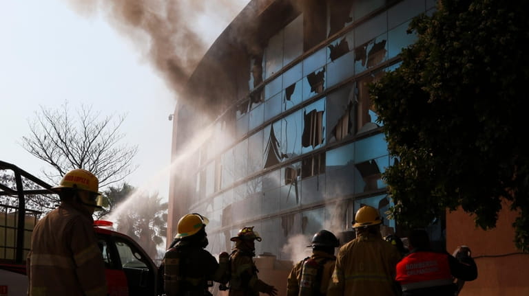 Firefighters work to put out a fire at the municipal...