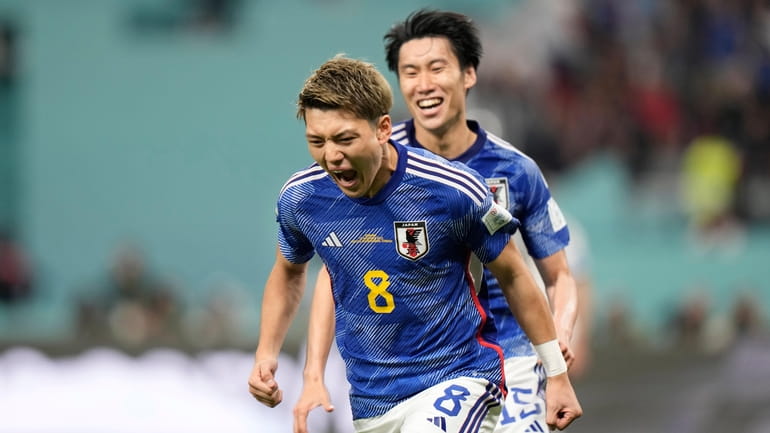 Japan's Ritsu Doan celebrates after scoring his side's opening goal...