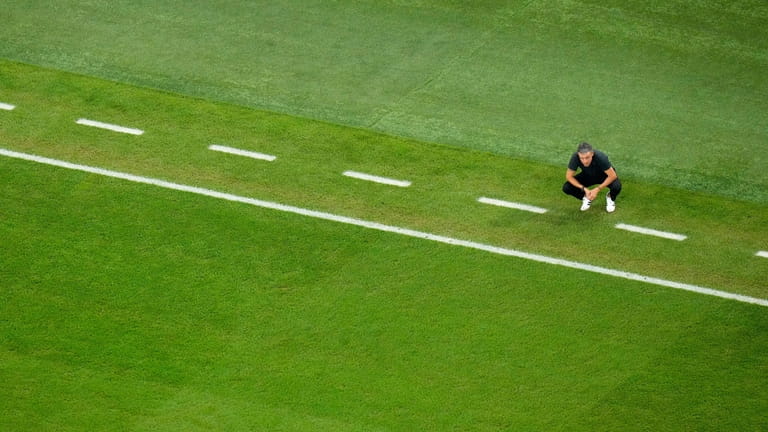Spain's head coach Luis Enrique crouches by the touchline during...