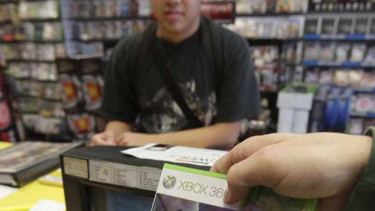 Joe Chen, 18, watches as his pre-ordered copy of the...