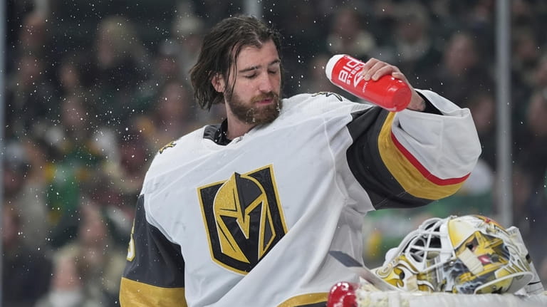 Vegas Golden Knights goaltender Logan Thompson douses his face with...
