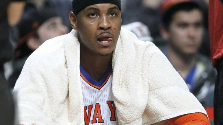 New York Knicks forward Carmelo Anthony sits on the bench...