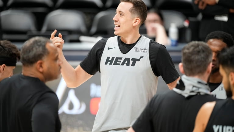 Miami Heat forward Duncan Robinson jokes with teammates during practice...