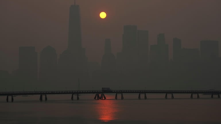 The sun rises over the Manhattan as seen from New Jersey,...