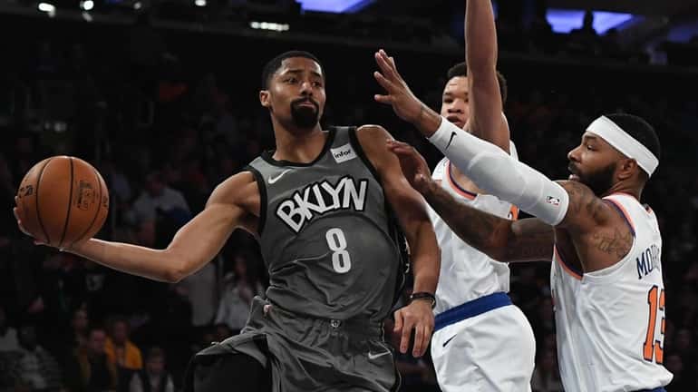 Nets guard Spencer Dinwiddie passes the ball from under the...