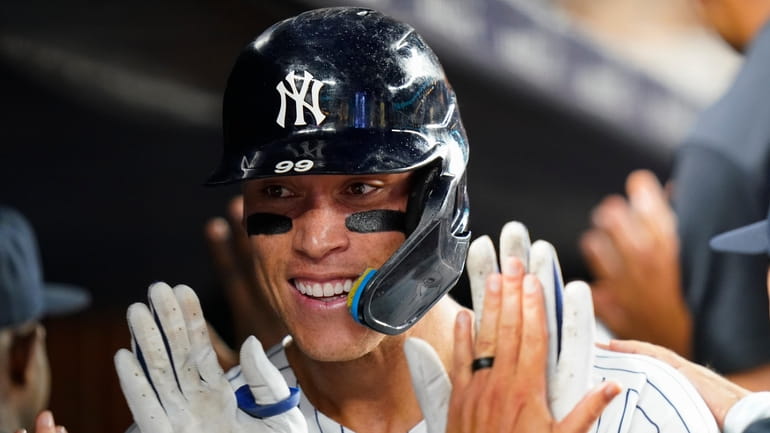 The Yankees' Aaron Judge celebrates with teammates after hitting a...