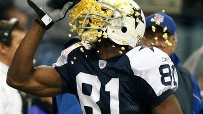 Then-Dallas Cowboys wide receiver Terrell Owens throws popcorn in his...