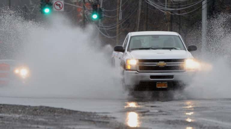 A pickup truck pours it on as it plows through...