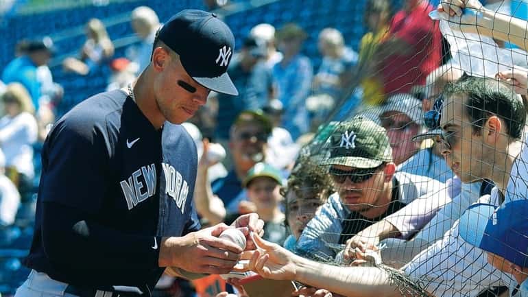 The Yankees' Aaron Judge signs autographs for fans before a...