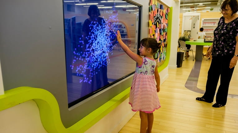 Samantha Sclavos, 5, of Port Washington plays "Fun with Particles" at...