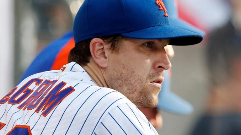 Jacob deGrom of the Mets looks on from the dugout after...