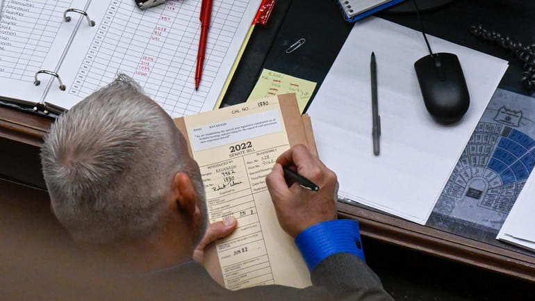 A clerk documents a bill in the Assembly Chamber at...