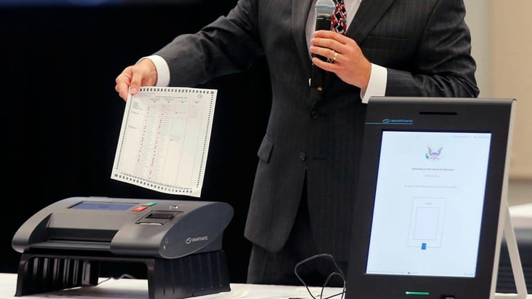 A Smartmatic representative demonstrates his company's system, which has scanners...