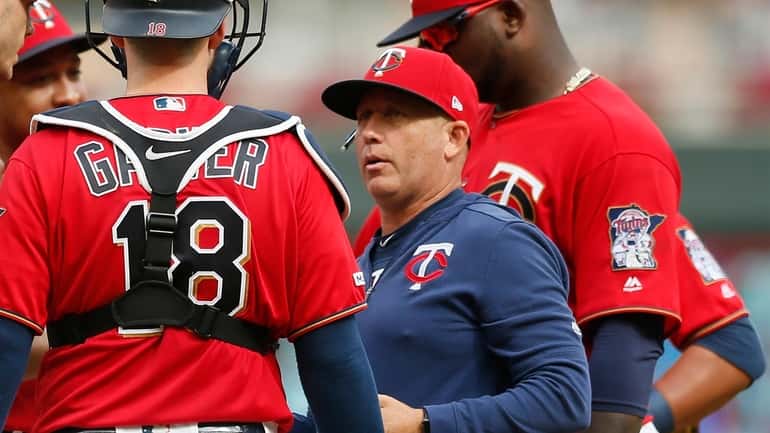 FILE - Minnesota Twins pitching coach Wes Johnson, right, holds...