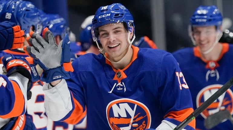 New York Islanders' Mathew Barzal celebrates with teammates after scoring a...