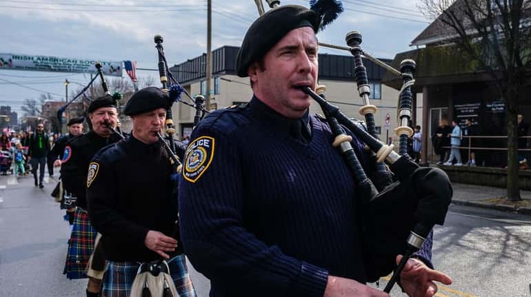 Police bagpipers march along Mineola Boulevard during the Mineola St....