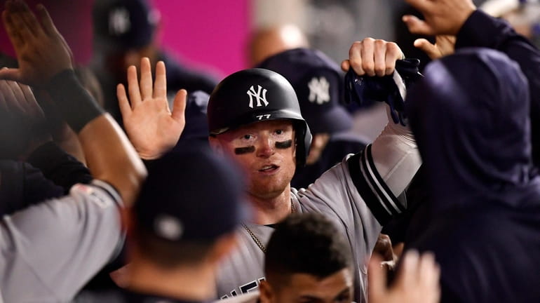 Yankees' Clint Frazier is congratulated by teammates after scoring on...