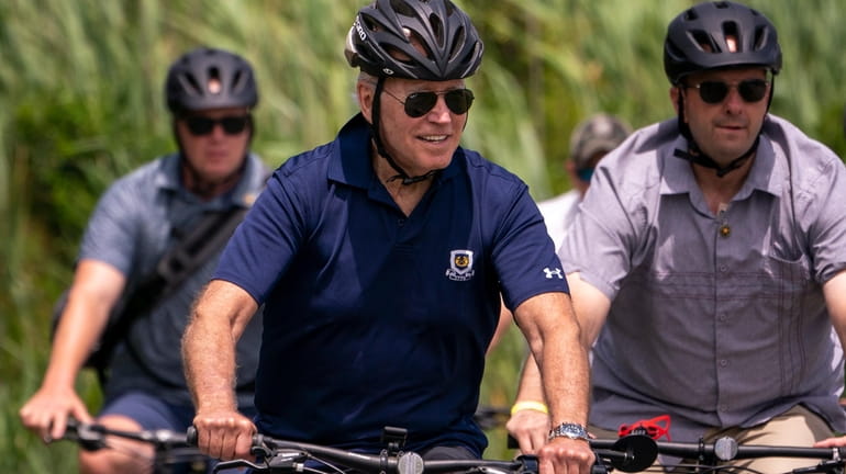 President Joe Biden rides a bicycle in Gordons Pond State Park...