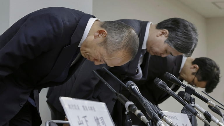 Akihiro Kobayashi, President of Kobayashi Pharmaceutical Co., left, bows during...