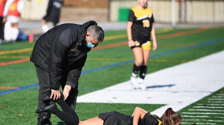St. Anthonys athletic trainer Ed Modica attends a player during...