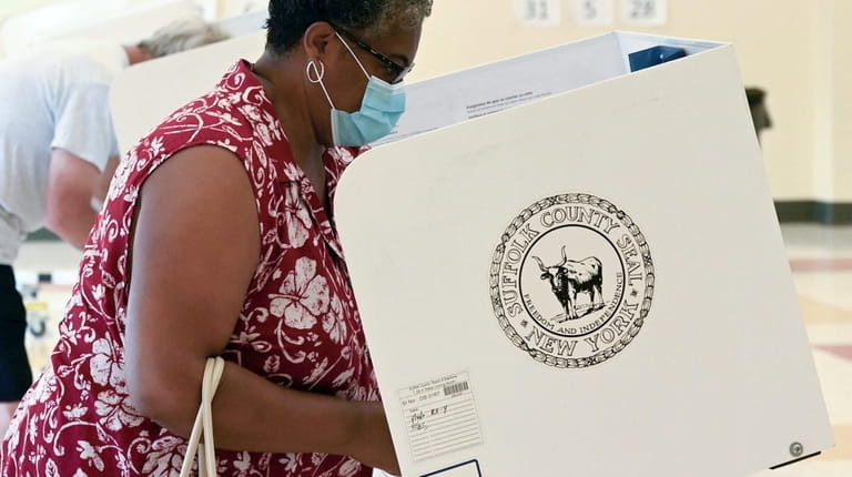 A voter casts a ballot at Aquebogue Elementary School on...