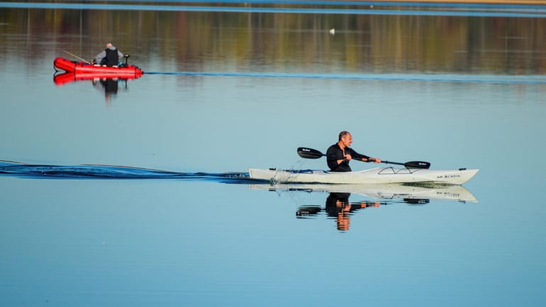 A kayaker makes his way across Lake Ronkonkoma Sunday on...