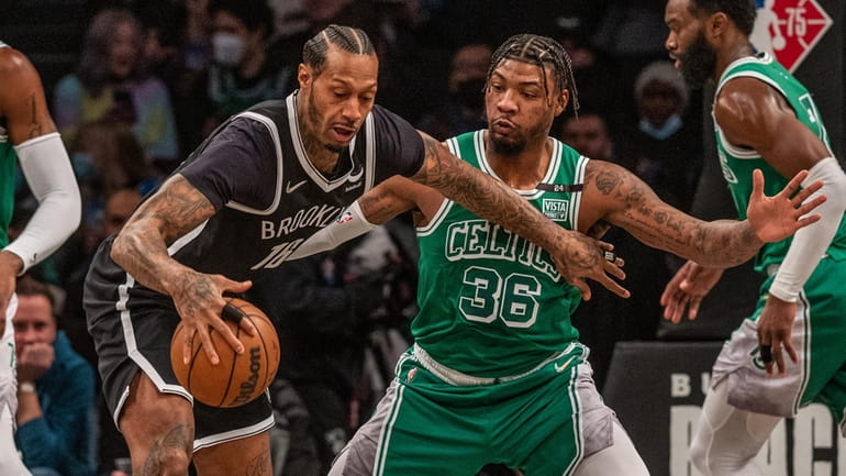 The Nets' James Johnson gets defensive pressure from Marcus Smart...