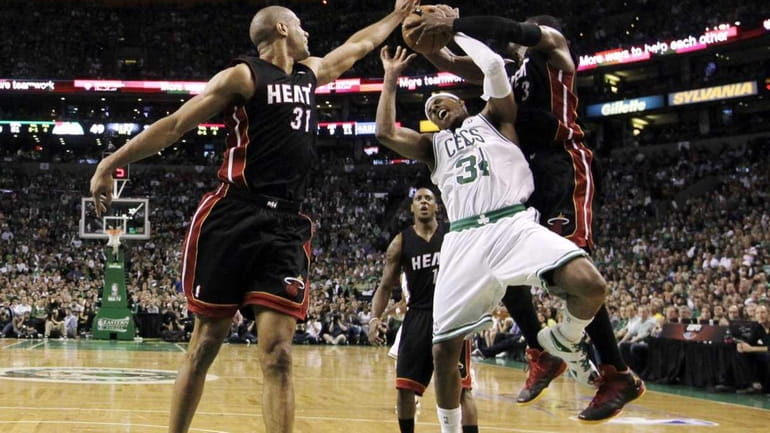 Miami Heat guard Dwyane Wade, right, ties up Boston Celtics...