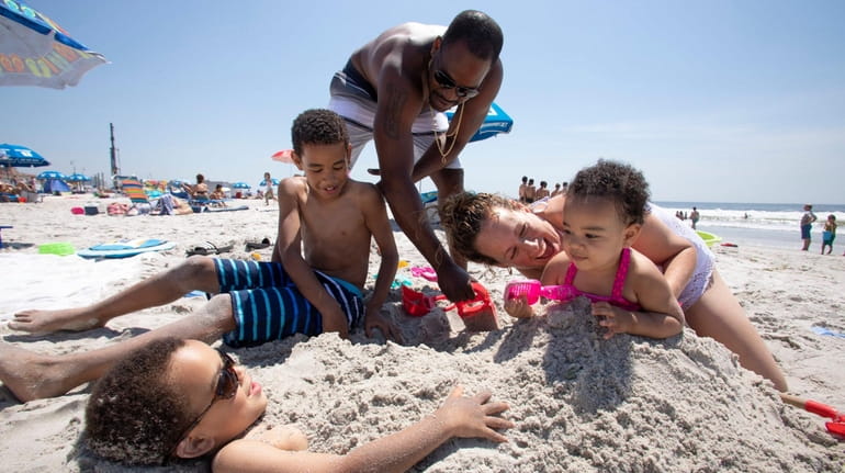 Trae Richards, 5, left, gets buried in the Long Beach...