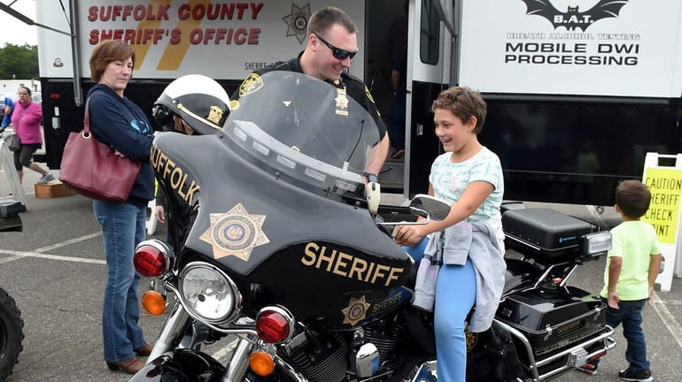 Deputy Sheriff Chris Anderson watches as Nathalie Bartholomew, 9, of...