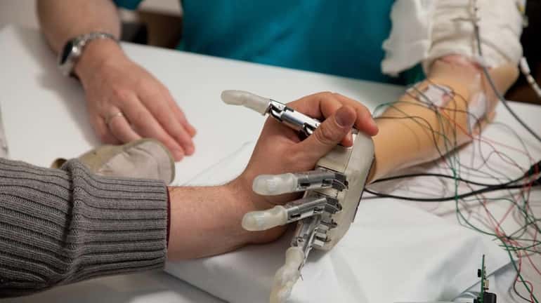 A sensory feedback enabled prosthetic hand goes through testing in...