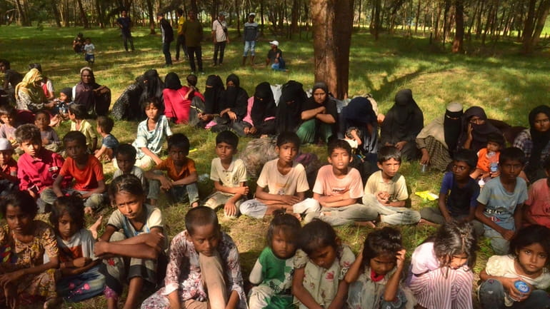 Ethnic Rohingya sit on a beach after they land in...