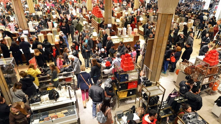 People crowd the first floor of Macy's department store as...