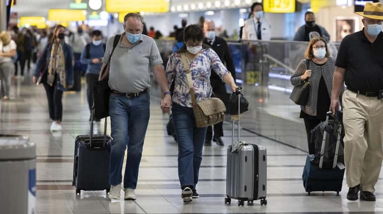 Travelers walk through Terminal 4 at Kennedy International Airport in...