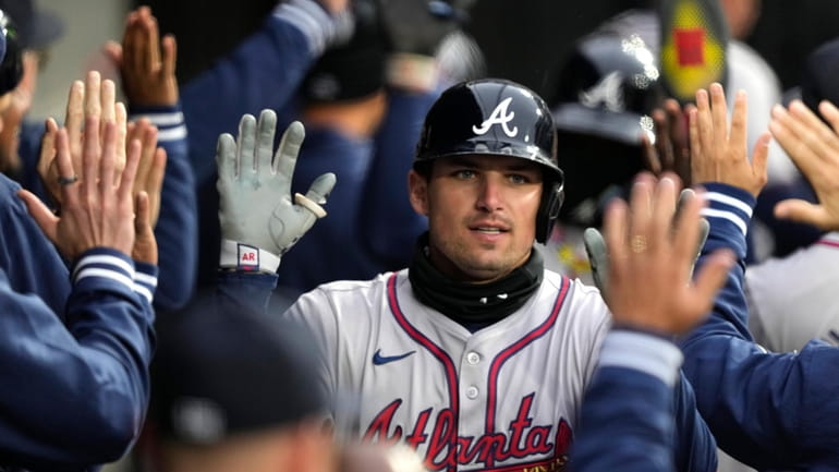 Atlanta Braves' Austin Riley is greeted in the dugout after...