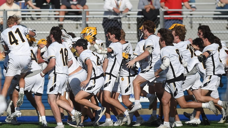 St. Anthony's teammates mob together in celebration after their 10-9...