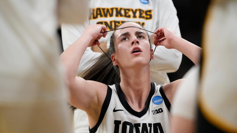 Iowa guard Caitlin Clark (22) adjusts a headband during a...